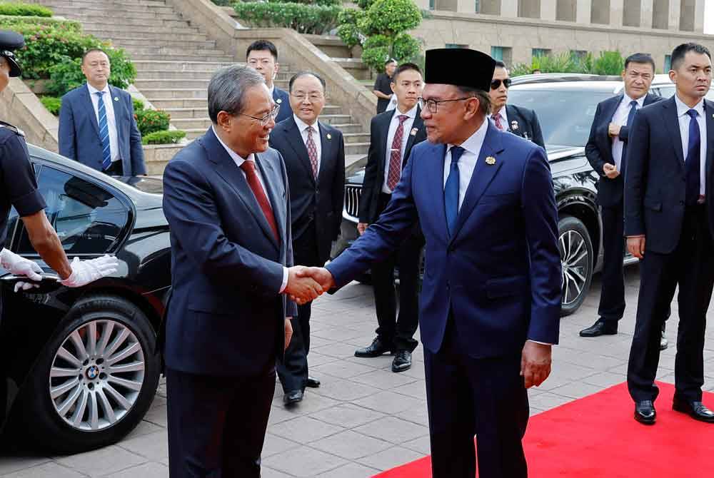 Anwar menyambut kedatangan Li Qiang (kiri) ke bangunan Perdana Putra sempena Lawatan Rasmi pada Rabu. Foto Bernama