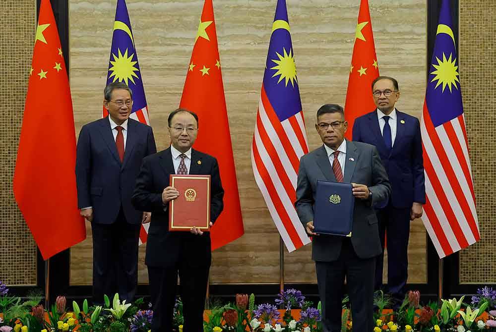 Anwar (kanan) bersama Qiang (kiri) menyaksikan pertukaran memorandum persefahaman antara Menteri Dalam Negeri Datuk Seri Saifuddin Nasution Ismail (dua, kanan) dan Duta Besar China ke Malaysia Ouyang Yujing di Bangunan Perdana Putra, hari ini. - Foto: Bernama