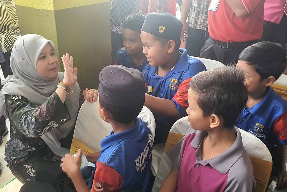 Fadhlina (kiri) beramah mesra dengan murid-murid SK Sungai Bakap yang hadir pada majlis peluncuran Sekolah Pengajar Program Sahabat Bahasa Institut Pendidikan Guru Malaysia pada Khamis.