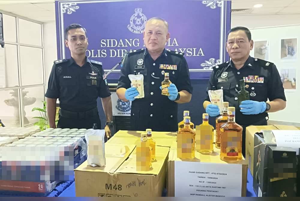 Mohd Sohaimi (tengah) menunjukkan sebahagian arak seludup yang dirampas, pada sidang akhbar di IPD Seri Alam, Johor Bahru pada Khamis