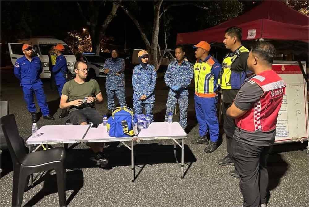 Mangsa duduk keletihan selepas diselamatkan akibat terkandas lebih tujuh jam di Gunung Mat Chinchang sejak malam Rabu.