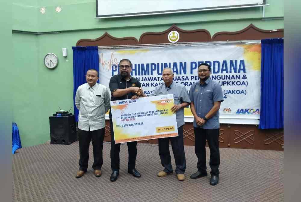 Ramli (dua dari kiri) menyampaikan Anugerah Jawatankuasa Pembangunan dan Keselamatan Kampung Orang Asli Paling Aktif sempena Majlis Perasmian Perhimpunan Perdana Batin dan Jawatankuasa Pembangunan Keselamatan Kampung Orang Asli peringkat Jabatan Kemajuan Orang Asli Negeri Perak dan Kedah Tahun 2024 di Dewan Utama Institut Tadbiran Islam Perak di sini pada Khamis.