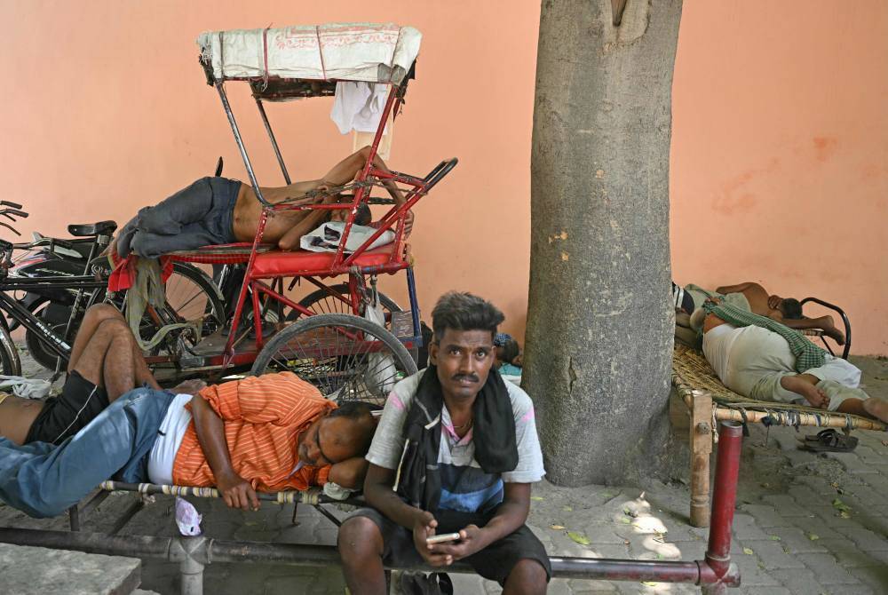 Orang ramai berehat dan berlindung daripada cuaca panas di New Delhi. Foto AFP