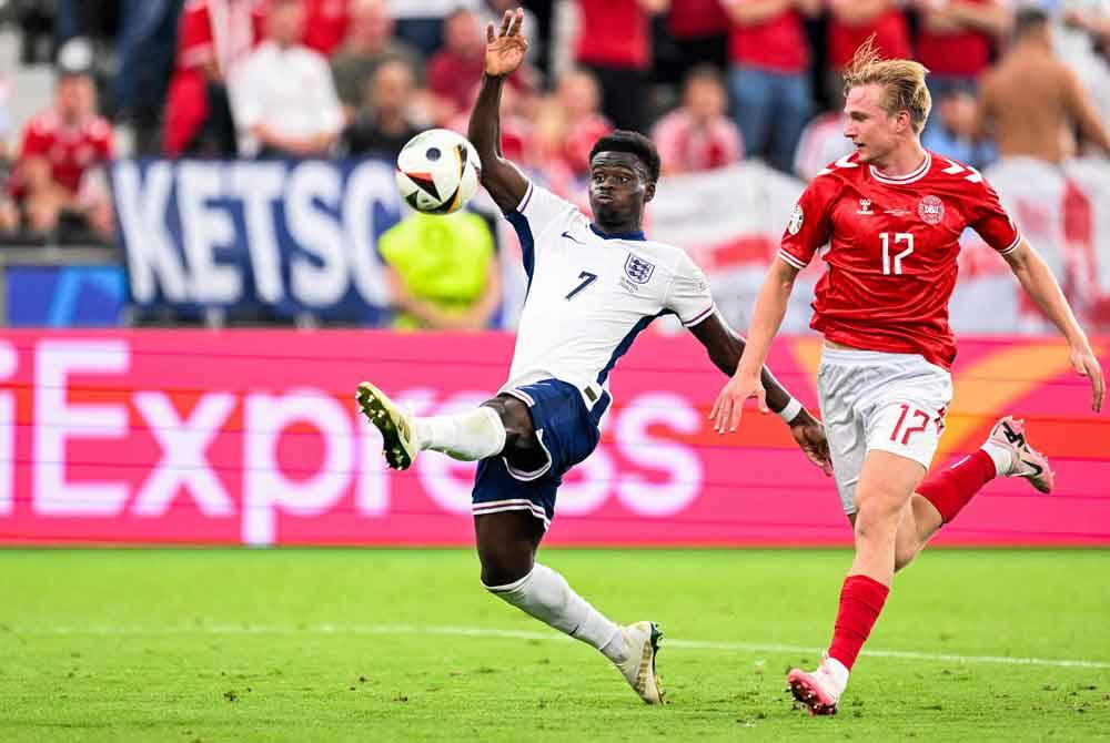 Pemain England, Bukayo Saka (kiri) dan pertahanan Denmark, Victor Kristiansen bersaing untuk merebut bola dalam aksi Euro 2024. Foto AFP