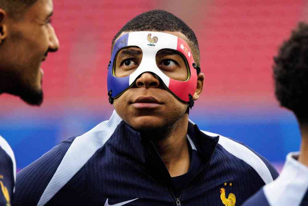 Mbappe memakai topeng warna bendera Perancis ketika menjalani latihan menjelang aksi menentang Belanda pada awal pagi Sabtu. Foto EPA