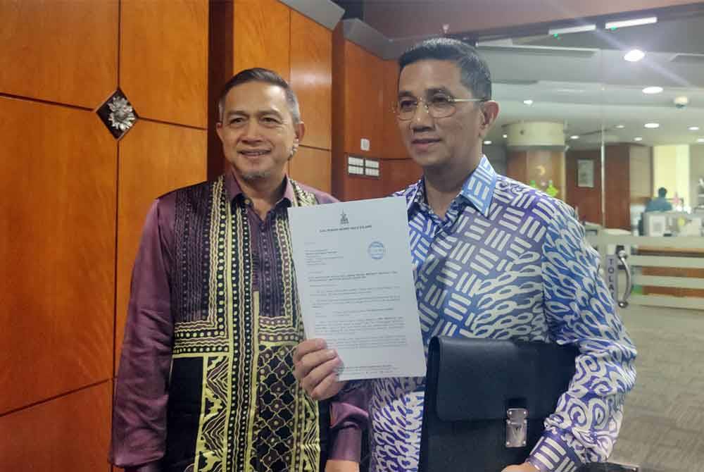 Mohamed Azmin (kanan) dan Shafie (kiri) menunjukkan notis bertulis kekosongan luar jangka kerusi DUN Selat Klang di Wisma DUN Selangor pada Jumaat.