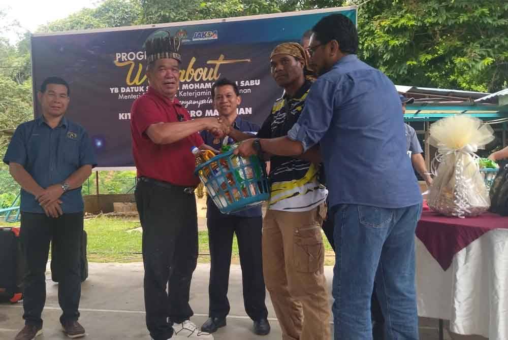 Mohamad (dua dari kiri) turut menyampaikan sumbangan kepada penerima sempena Program Walkabout di Dewan Terbuka Kampung Sungai Raba di sini pada Jumaat.