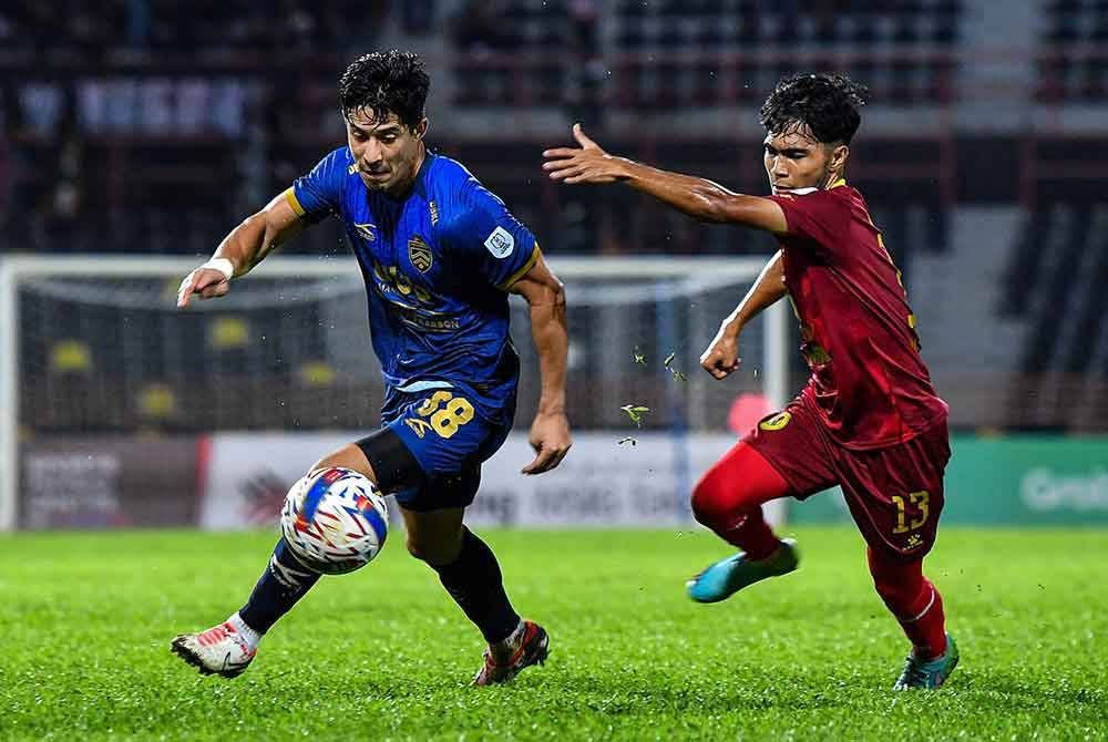 Pemain Negeri Sembilan, Mohamad Ikhwan Yazek (kanan) bersaing dengan Brendan Gan pada perlawanan Liga Super di Stadium Tuanku Abdul Rahman Paroi.