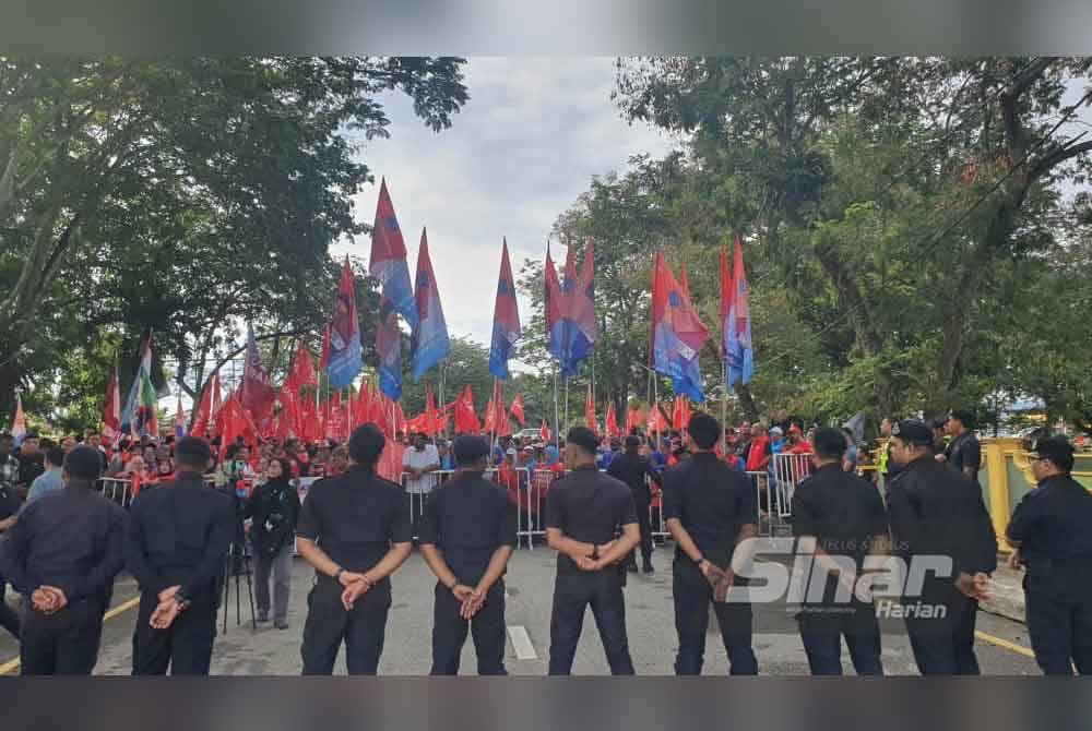 Anggota polis berkawal berhampiran tempat penyokong Pakatan Harapan di pusat penamaan calon di Dewan Serbaguna Jawi, Pulau Pinang.