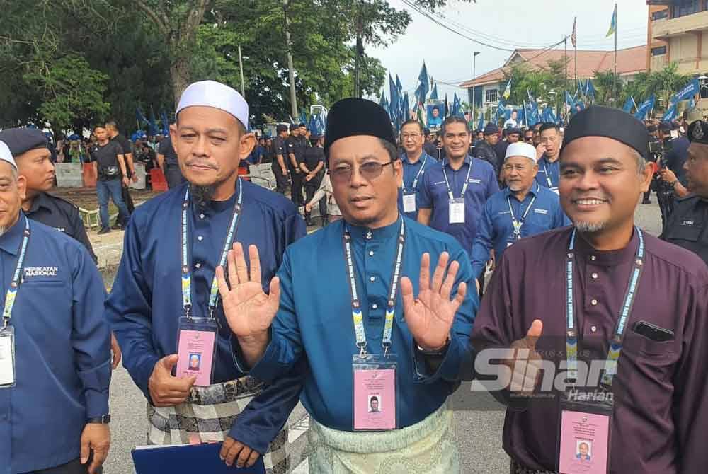 Abidin (tengah) bersama pencadang dan penyokongnya tiba di Dewan Serbaguna Jawi untuk proses penamaan calon, pada Sabtu.