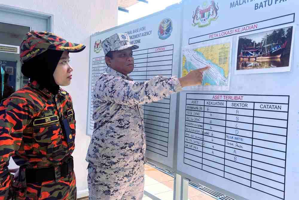 Mohd Haniff (kanan) menunjukkan lokasi bot dinaiki empat nelayan yang dilaporkan hilang di perairan Tanjung Segenting pada Jumaat. Foto Bernama