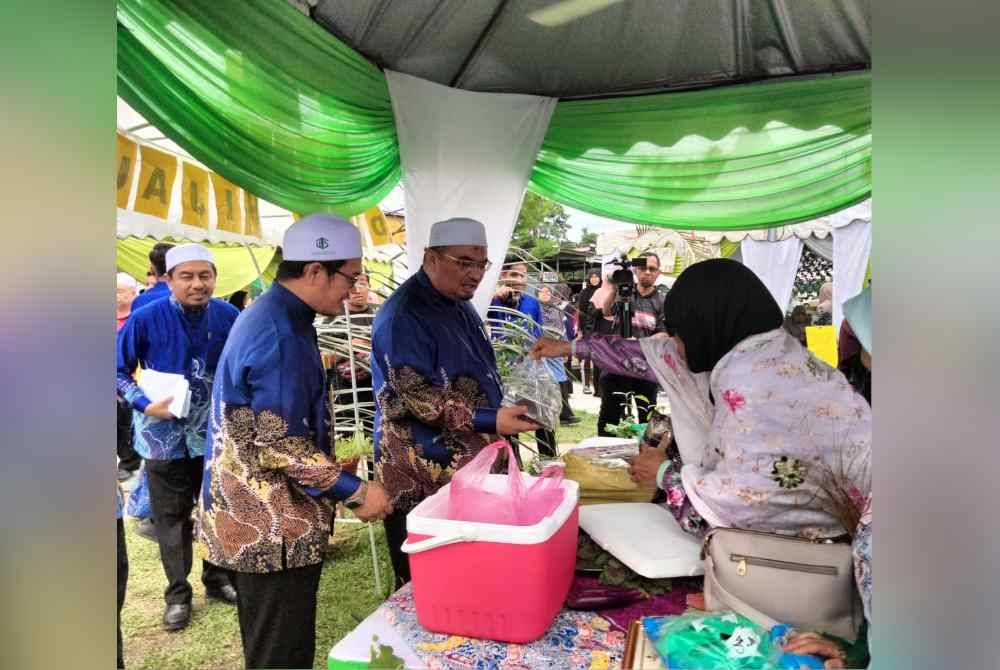 Tuan Mohd Saripudin (kanan) mengiringi Mohamed Fadzli meninjau tanaman hasil tanaman program Dapur Hijau