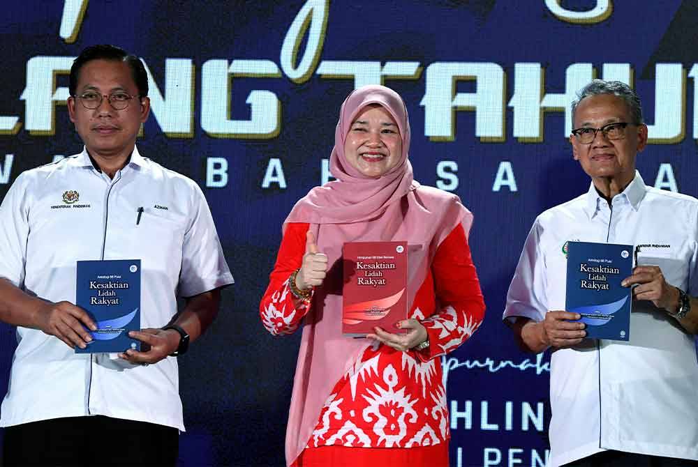 Fadhlina (tengah) menunjukkan buku Kesaktian Lidah Rakyat yang dirasmikan pada Majlis Sambutan Ulang Tahun Ke-68 DBP di Sekolah Menengah Kebangsaan Seri Nibong pada Sabtu. Foto Bernama