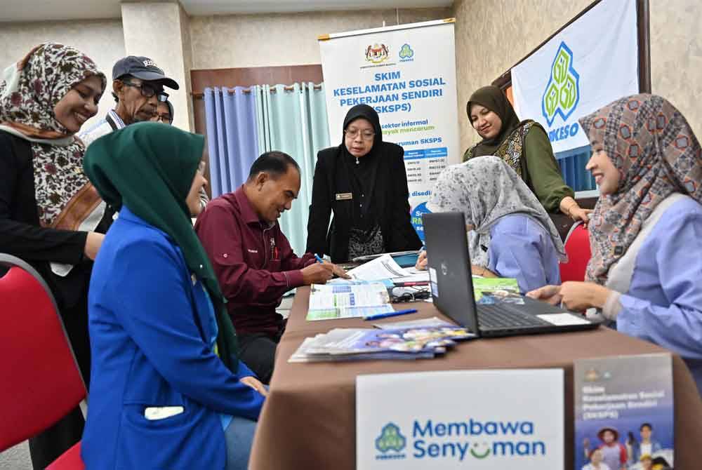 Farihah (tengah) melihat proses mendaftar SKSPS pada Ahad.