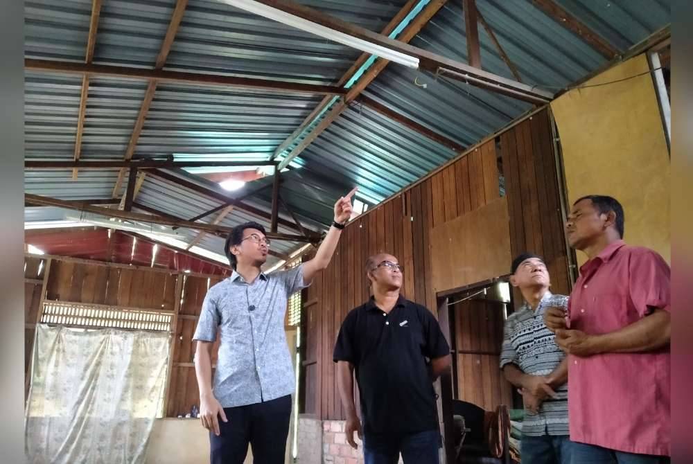 Muhammad Kamil (kiri) melawat sebuah rumah ketika Program Ziarah Kasih Madani di Kampung Jenalik Hulu di Padang Rengas pada Selasa.