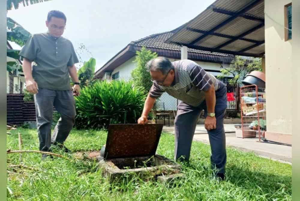 Mohd Nordin (kanan) bersama Azman ketika melakukan pemeriksaan pembiakan nyamuk Aedes di kediaman penduduk.