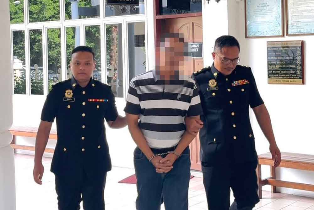 Suspek (tengah) diiringi pegawai SPRM Sarawak selepas selesai dikenakan tahanan reman di Mahkamah Majistret Bintulu pada Selasa.