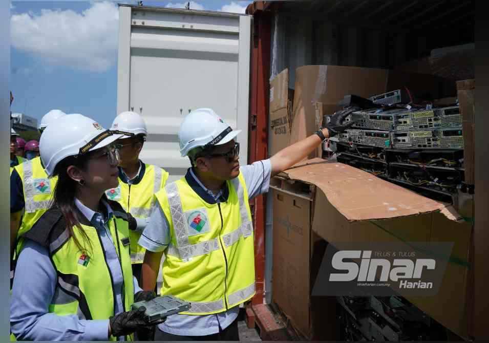 Nik Nazmi melihat komponen komputer ketika lawatan kerja dan operasi gempur kontena berisi bahan buangan terjadual, e-waste di Westport, Pelabuhan Klang pada Rabu. - FOTO: SINAR HARIAN/ROSLI TALIB