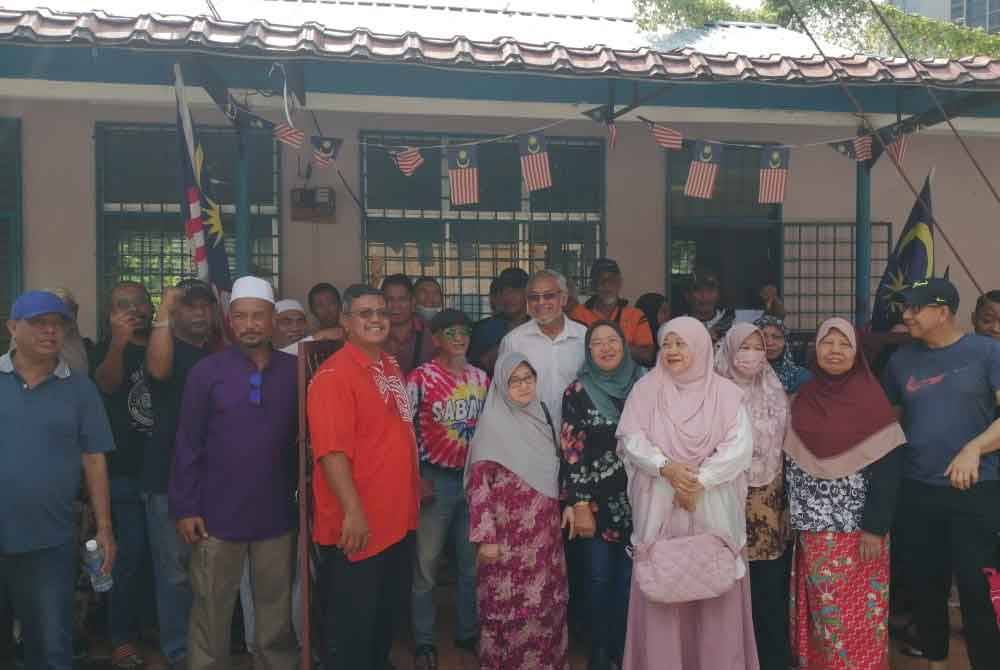 Khalid (tengah) bersama penduduk pada sidang akhbar di Kampung Sungai Baru pada Rabu.