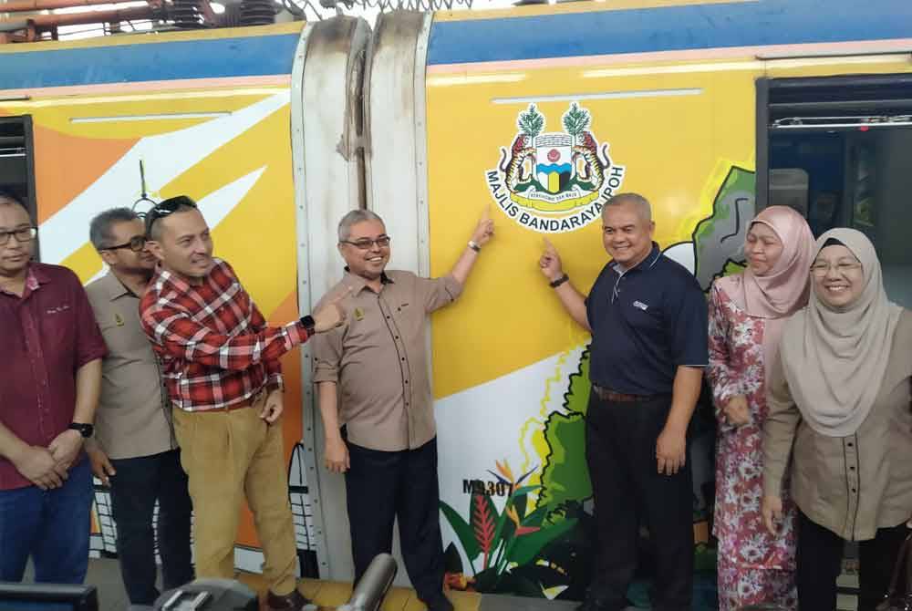 Rumaizi (tengah) ketika menyempurnakan Majlis Pelancaran Pengiklanan Pakej Promosi Maklumat Produk dan Tempat Pelancongan Menarik di Bandar raya Ipoh Melalui ETS di Stesen Kereta Api Ipoh di sini.