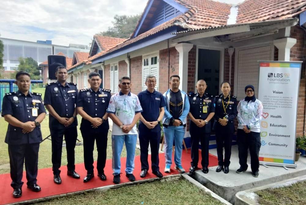 Muhammad Izham (empat dari kiri) dan Hock San (lima dari kanan) bergambar di hadapan Rumah Kelab Sepak Takraw PDRM.