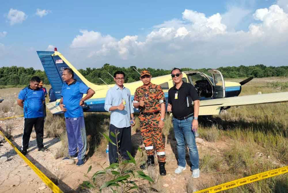 Wan Md Razali (dua dari kanan) bergambar bersama dua juruterbang pesawat ringan yang terselamat selepas membuat pendaratan cemas di kawasan lapang berhampiran Bandar Sultan Suleiman, Pelabuhan Klang, Selangor pada Khamis.
Foto: JBPM.