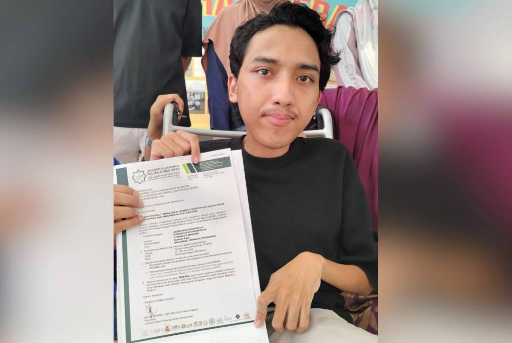 Muhamad Adib Nadhir bersama surat tawaran mengikuti pengajian Program Asasi Kemanusiaan yang diserahkan sendiri Dr Mohd Zawavi dalam satu majlis ringkas di SMK Chengal Lempong di sini pada Jumaat.