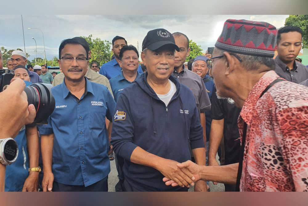 Muhyiddin ketika menyantuni pengundi di Unit Daerah Mengundi Puteri Gunung di Simpang Ampat, pada Jumaat.