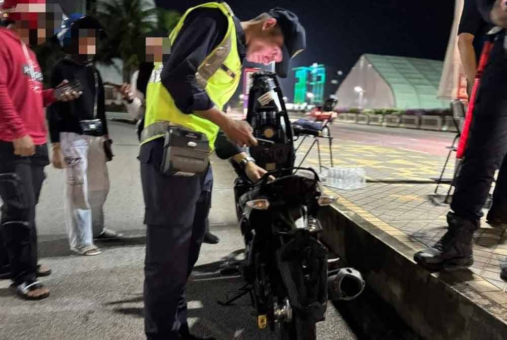 Anggota penguat kuasa JPJ Pahang melakukan pemeriksaan ke atas motosikal digunakan remaja yang ditahan dalam sekatan jalan Ops Khas Motosikal JPJ Pahang di Jalan Tanah Putih di sini, malam Khamis lalu. Foto FB JPJ Pahang