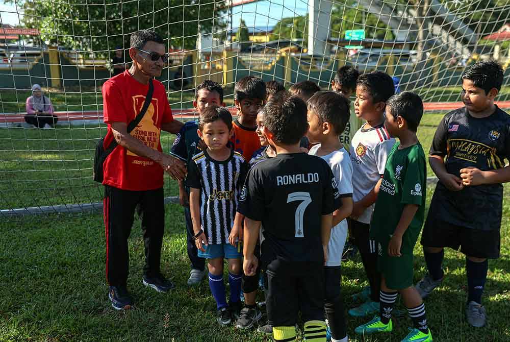 Abdul Halim bersama peserta ketika hadir pada Klinik Bola Sepak Madani anjuran Kelab Bola Sepak DNA Faisal Halim di Padang Awam Jawi pada Sabtu. Foto Bernama