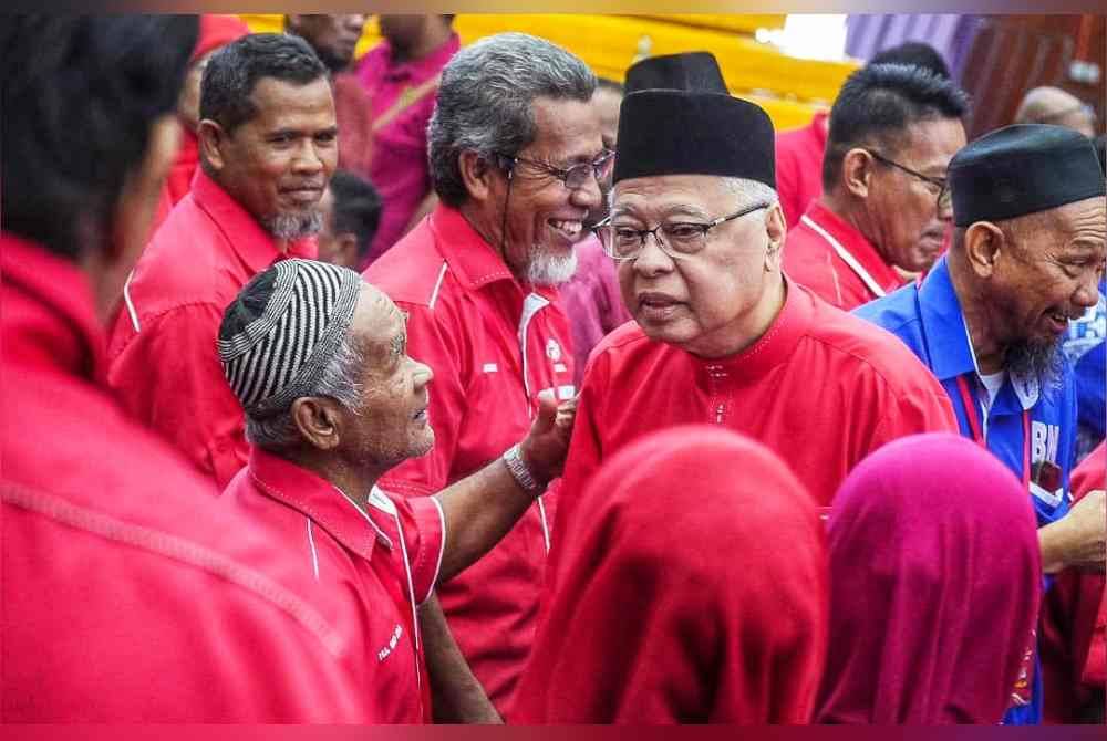 Ismail Sabri (kanan) menyantuni pewakilan yang hadir.