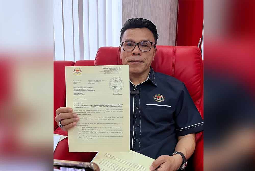 Mohd Azizi menunjukkan surat maklum balas mengenai kekosongan kerusi DUN Nenggiri di pejabatnya pada Ahad. Foto Bernama