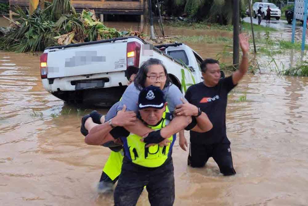 Sammy mendukung wanita warga emas terperangkap dalam sebuah pacuan empat roda yang terbabas disebabkan banjir di Jalan Kasigui, Penampang.