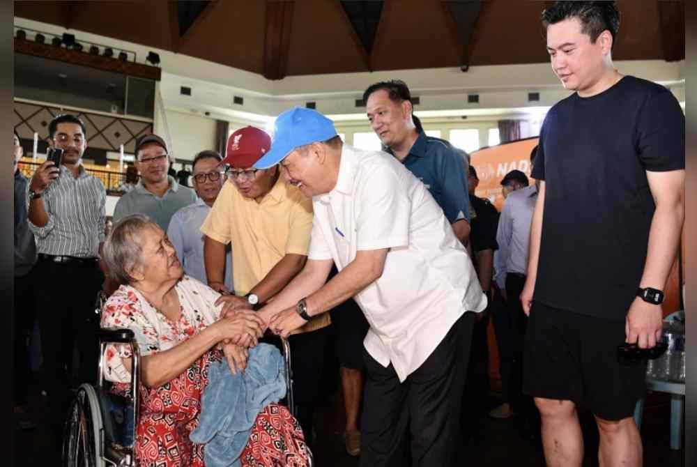 Hajiji Noor menyantuni mangsa-mangsa banjir yang ditempatkan di pusat pemindahan sementara (PPS) di Pusat Kebudayaan Penampang hari ini. Foto Bernama