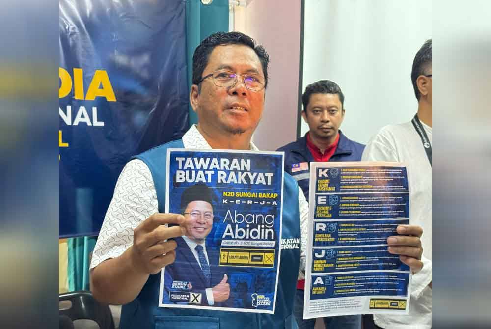 Abidin menunjukkan manifesto KERJA yang dilancarkan tiga hari sebelum hari mengundi bagi DUN Sungai Bakap.