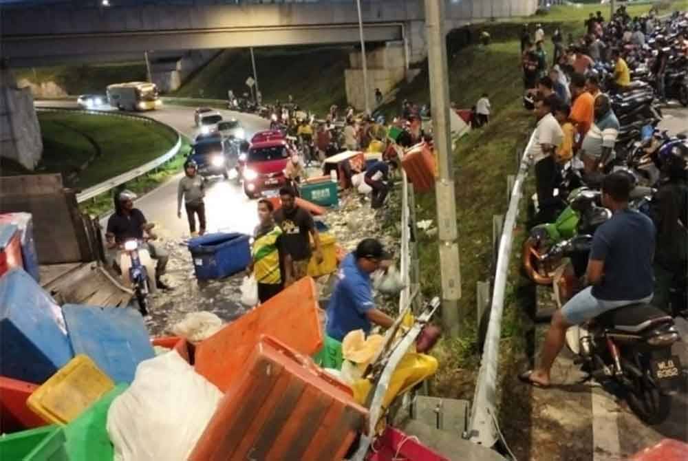 Orang ramai berebut mengambil sotong atas jalan raya di Jalan Kuala Selangor-Sungai Buloh, Selangor pada Isnin.
Foto ihsan PDRM