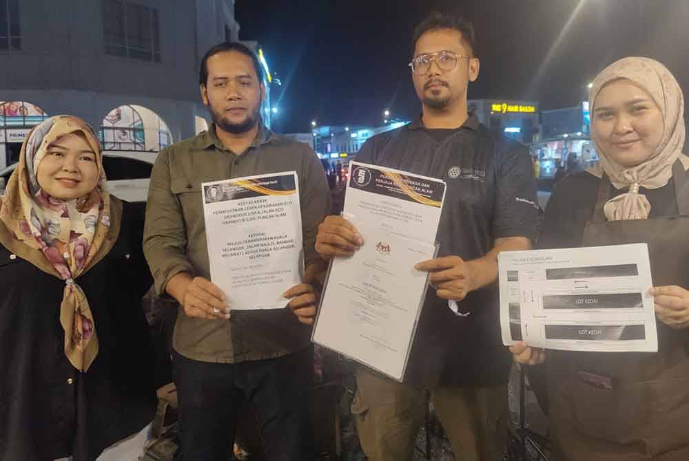 Mohd Faiz (dua dari kanan) menunjukkan salinan permohonan lesen penjaja di Jalan Eco Grandeur Puncak Alam bagi pertimbangan MPKS.