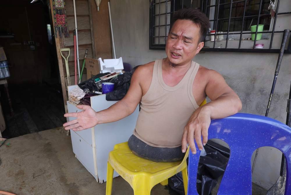 Francis Xavier menceritakan pengalamannya ketika banjir kilat yang menimpa rumahnya pada petang Ahad lalu di Kampung Dabak Penampang. Foto Bernama