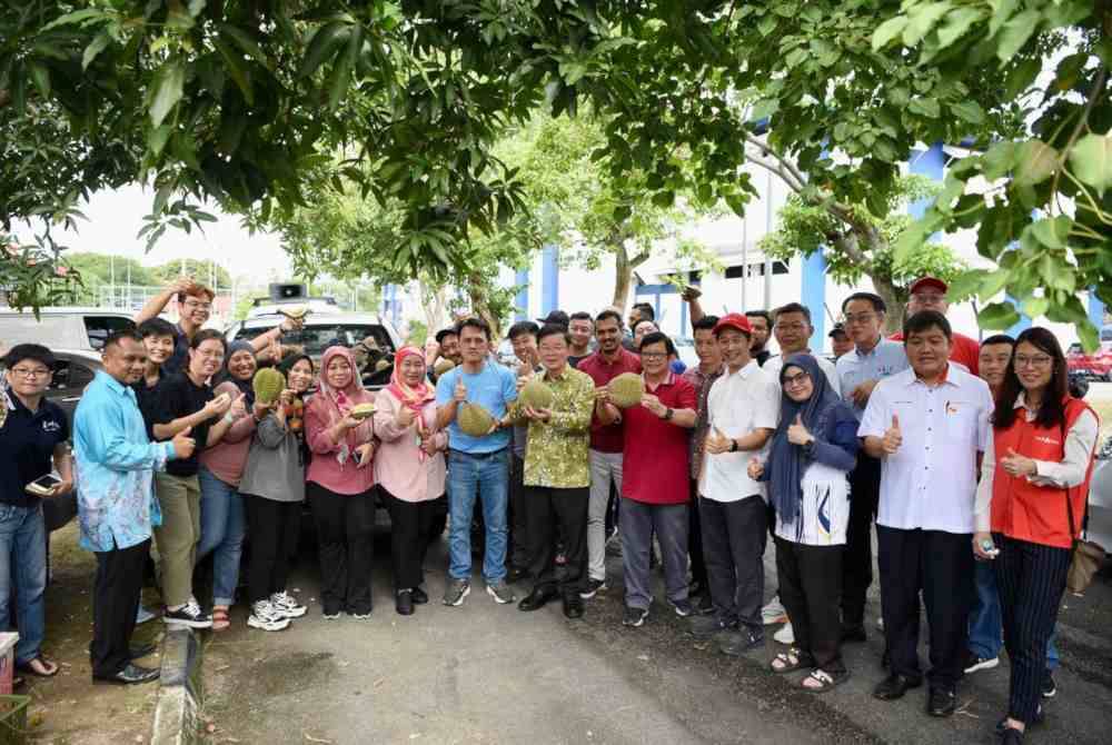 Kon Yeow (tengah) bergambar bersama petugas media yang menyertai Program ‘Jom Pekena Durian Bersama CM Chow 2.0’ di pekarangan Kompleks Rakan Muda Jawi pada Khamis.