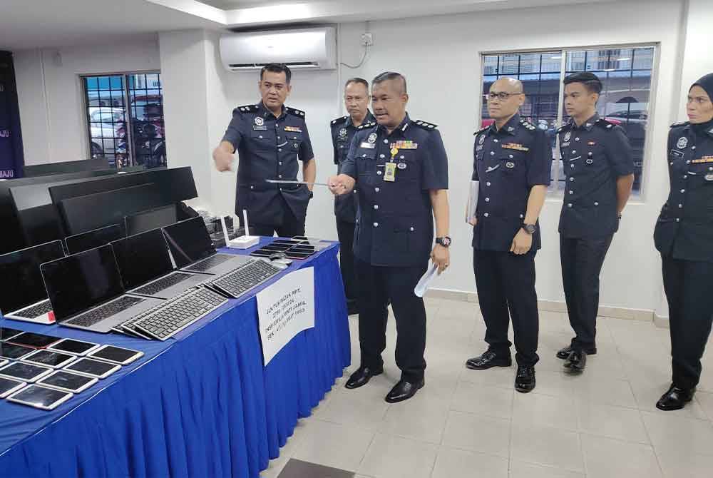 Mohamad Lazim menunjukkan antara rampasan susulan tumpasnya sindiket judi dalam talian di ibu negara, 27 Jun lalu.