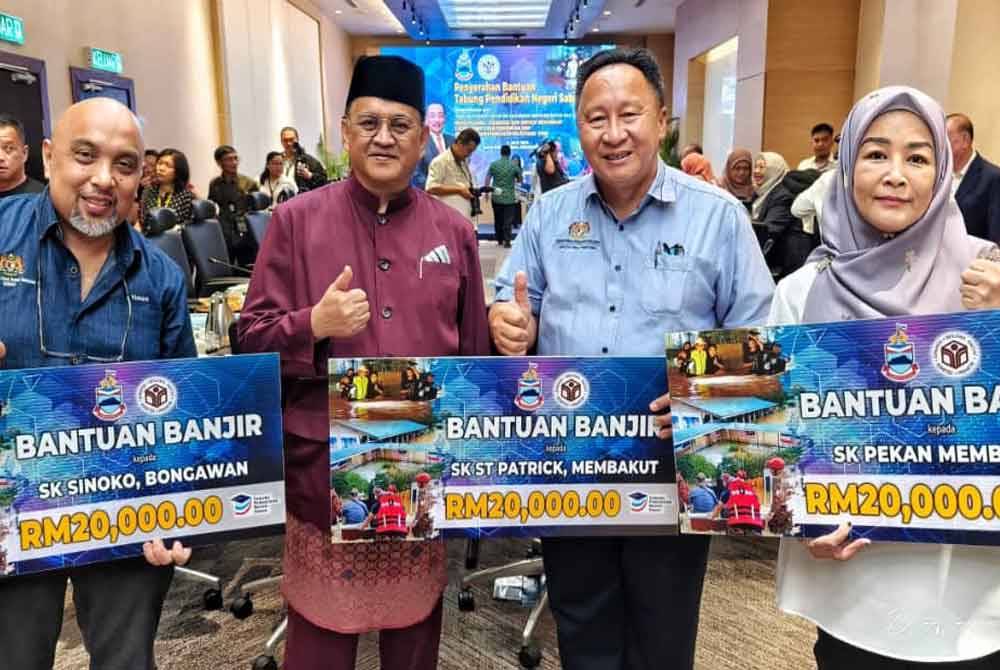 Mohd Arifin (dua dari kiri) bersama wakil sekolah yang menerima sumbangan daripada TPNS yang diadakan di SICC, Kota Kinabalu.