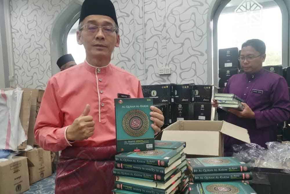 Hashim menunjukkan naskah al-Quran yang akan diedar pada sambutan Maal Hijrah.