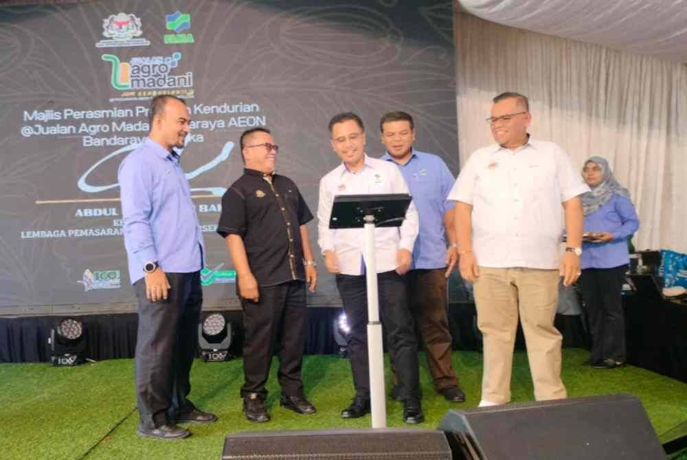 Abdul Rashid (tengah) menyempurnakan simbolik perasmian program Jom Kendurian @ Jualan Agro Madani di AEON Bandaraya Melaka di Melaka, pada Sabtu.