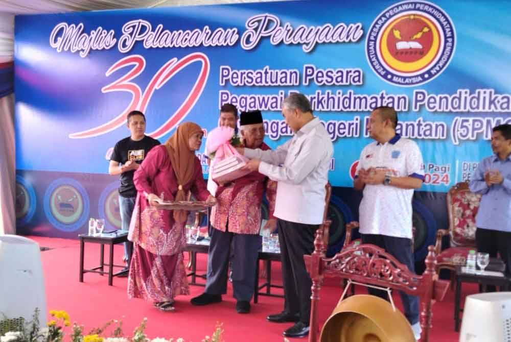 Ahmad Zahid (dua dari kanan) menerima cenderamata daripada Idris selepas Majlis Pelancaran Perayaan 30 Tahun Persatuan Pesara Pegawai Perkhidmatan Pendidikan Malaysia Cawangan Negeri Kelantan (5PMCK) pada Sabtu.