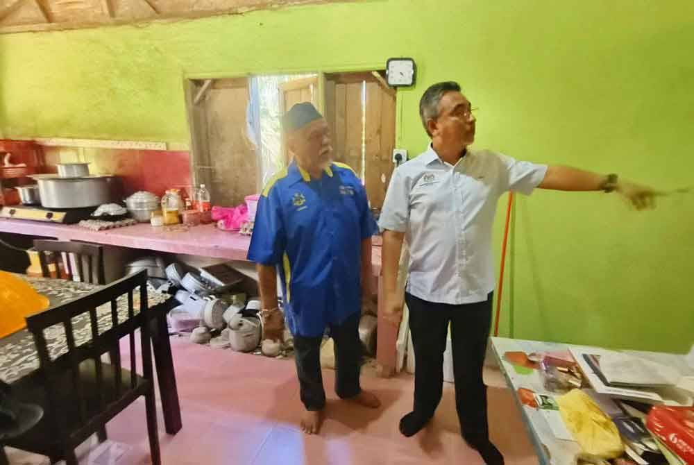 Adly (kanan) meninjau keadaan rumah salah seorang veteran ATM pada Program Veteran Desa Madani di Kampung Padang, Temangan, Machang pada Jumaat.