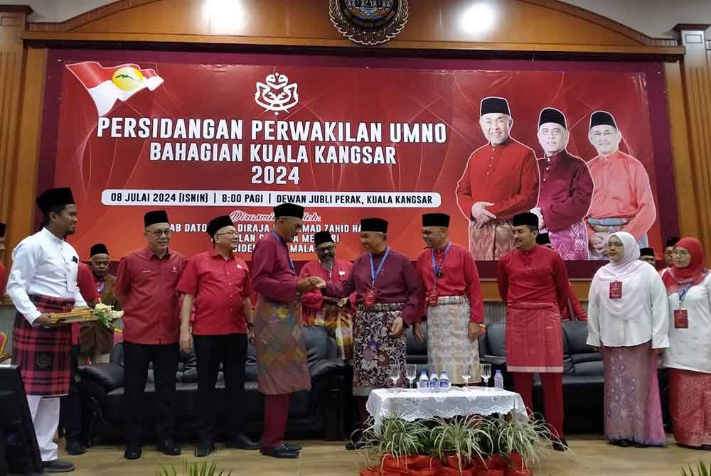 Ahmad Zahid (tengah) menerima cenderahati daripada Maslin Sham selepas menyempurnakan Persidangan Perwakilan UMNO Bahagian Kuala Kangsar 2024 di Dewan Jubli Perak pada Isnin.