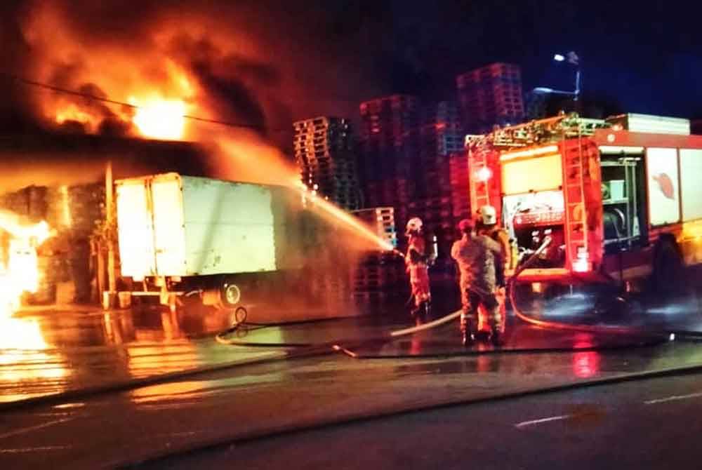 Anggota bomba memadam kebakaran melibatkan gudang menyimpan barangan runcit di Jalan Bukit Ubi pada Ahad.