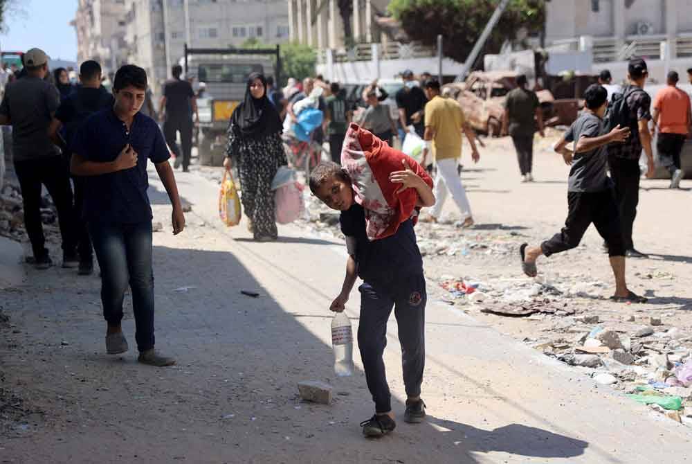 Pengeboman tentera Israel menyebabkan ribuan rakyat Palestin melarikan diri ke kawasan barat laut bandar berkenaan. Foto AFP.