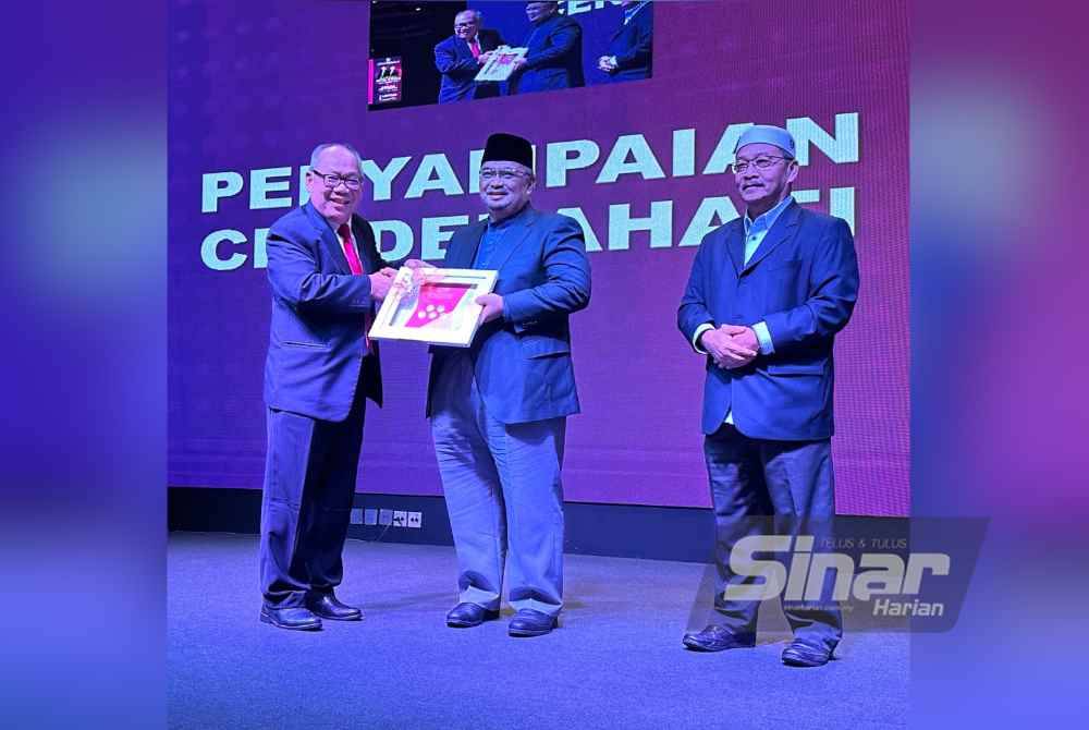 Mohamed Fadzli (tengah) menyampaikan cenderamata penghargaan kepada Pengarah Urusan Lynas Malaysia, Datuk Mashal Ahmad (kiri).