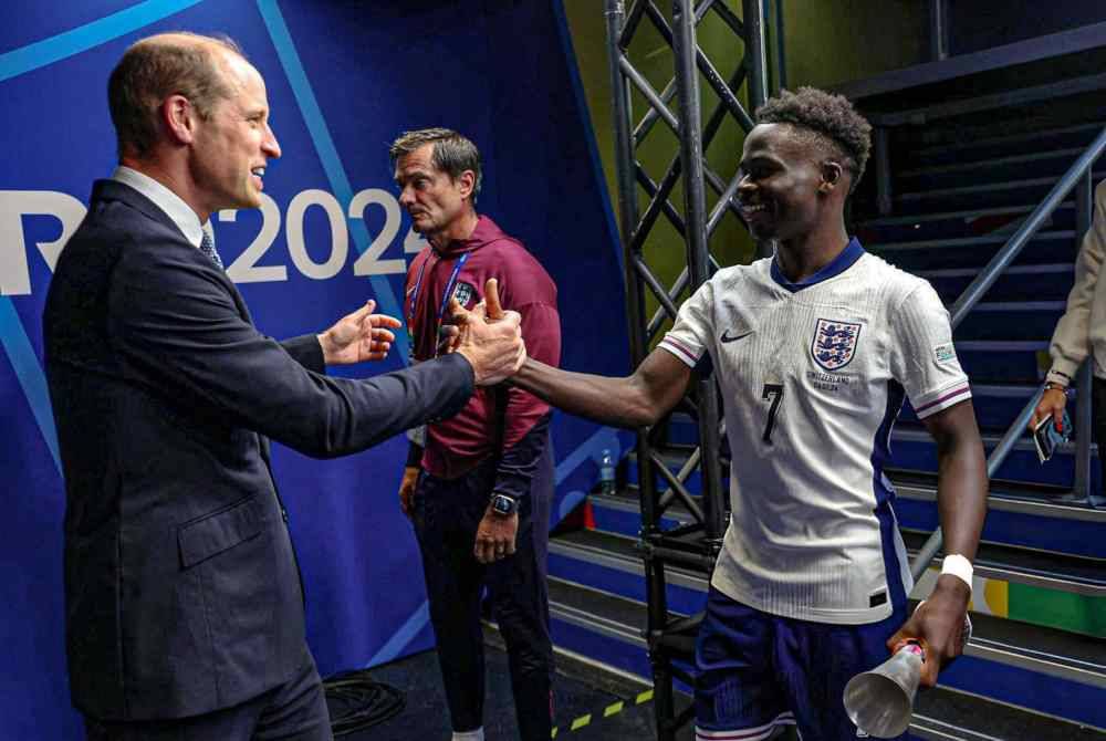 Pewaris takhta Britain, Putera William (kiri) mengucapkan tahniah kepada Saka selepas England menewaskan Switzerland untuk menempah slot separuh akhir Euro. Foto Agensi